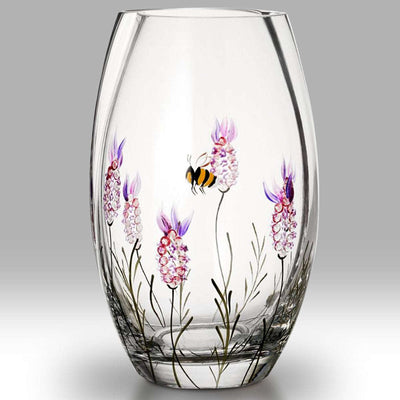 Clear glass vase with floral and bee design on a gray background