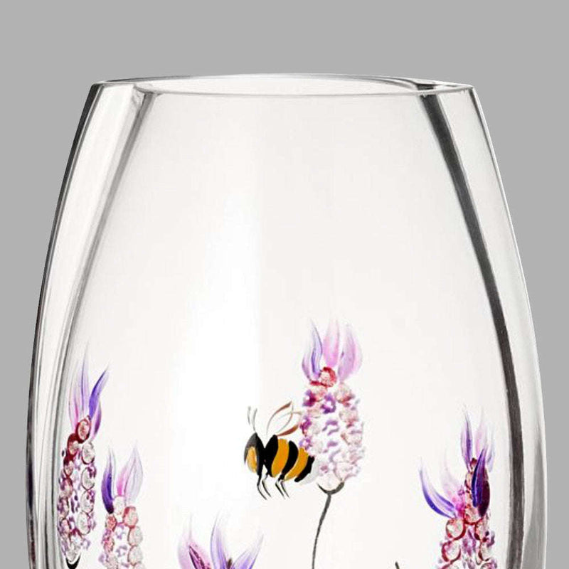 Clear glass vase with floral and bee design on a gray background