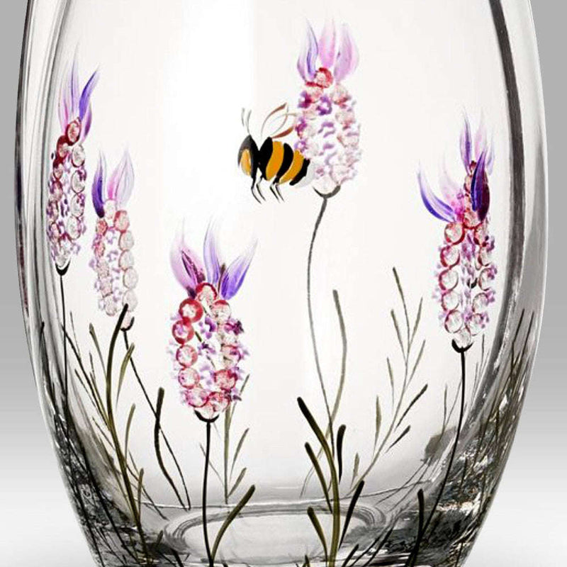 Clear glass vase with floral and bee design on a gray background