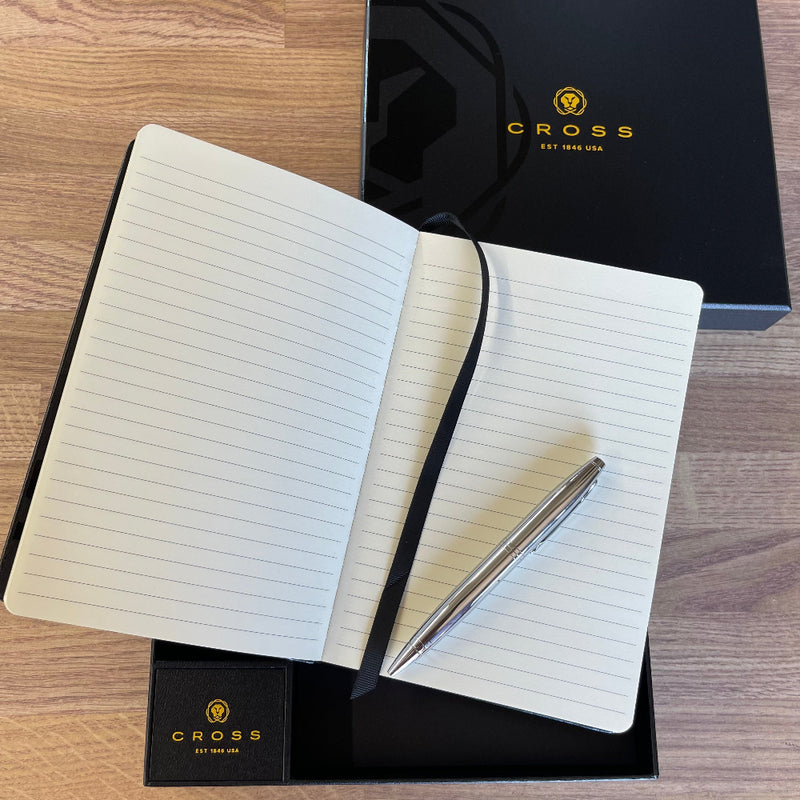 Open notebook with pen set including a Cross branded box.